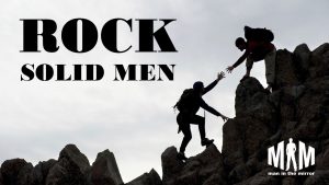 Rock Solid Men, one man helping another up a trail